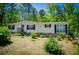 Inviting one-story home with neutral siding, black shutters, a red front door, and well-maintained landscaping at 1530 Mcbrayer Rd, Temple, GA 30179