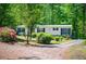 Inviting one-story home with black shutters surrounded by colorful mature landscaping and mature trees at 1530 Mcbrayer Rd, Temple, GA 30179