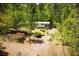 Home with well-manicured yard, set back from a gravel drive, surrounded by mature trees and lush greenery at 1530 Mcbrayer Rd, Temple, GA 30179