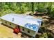 This home's backyard boasts a metal roof, a rear entrance with a red deck, and a green lawn, creating a serene retreat at 1530 Mcbrayer Rd, Temple, GA 30179