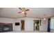 View of living room with fireplace and television from open doorway, adjoining kitchen, and fan overhead at 1530 Mcbrayer Rd, Temple, GA 30179