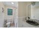 Well-lit bathroom featuring tiled walls, toilet, shower, and black tiled sink and mirror at 165 Holly Ct, Loganville, GA 30052