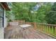 Wooden deck featuring a table, showcasing outdoor relaxation and scenic views of the surrounding lush greenery at 165 Holly Ct, Loganville, GA 30052