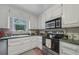 Bright kitchen with white cabinets and stainless steel appliances at 165 Holly Ct, Loganville, GA 30052