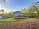 Expansive backyard with lush green lawn, mature trees and a view of the home's back elevation at 1005 Liberty Springs Dr, Woodstock, GA 30188