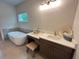 Spa-like bathroom featuring a soaking tub, vanity area, and soft lighting for a tranquil experience at 1005 Liberty Springs Dr, Woodstock, GA 30188