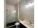 Modern bathroom features a glass shower, black herringbone tile, and a vanity with a white countertop at 1005 Liberty Springs Dr, Woodstock, GA 30188