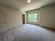 Spacious bedroom with plush carpeting, a large window providing natural light, and neutral wall paint at 1005 Liberty Springs Dr, Woodstock, GA 30188