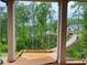 View from the covered porch framed by wooden columns overlooks the driveway and neighboring home at 1005 Liberty Springs Dr, Woodstock, GA 30188