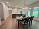 Bright dining area boasts an open floorplan to the kitchen, with hardwood floors and natural light at 1005 Liberty Springs Dr, Woodstock, GA 30188