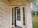 View of front door with sidelights, white trim and brick exterior at 1005 Liberty Springs Dr, Woodstock, GA 30188