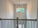 Upstairs view of the foyer with a modern chandelier and large window for natural light at 1005 Liberty Springs Dr, Woodstock, GA 30188