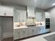 Modern kitchen with white cabinetry, quartz countertops, stainless steel appliances, and chevron backsplash at 1005 Liberty Springs Dr, Woodstock, GA 30188
