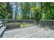 Spacious deck with wood plank flooring and a wooden fence with greenery in the background at 4135 Brenda Dr, Decatur, GA 30035