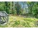 A backyard with a wooden fence, grass and trees, viewed from a deck with stairs at 4135 Brenda Dr, Decatur, GA 30035