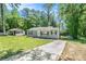 View of the home with a long concrete driveway and green lawn surrounded by mature trees at 4135 Brenda Dr, Decatur, GA 30035