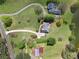 Aerial view of a home with a large yard, long driveway, and pond in a wooded setting at 4790 Hyde Rd, Cumming, GA 30040