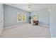 Light-filled bedroom with soft blue walls, neutral carpet, ceiling fan, and backyard view at 4790 Hyde Rd, Cumming, GA 30040