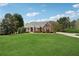 Well-manicured front yard with lush green grass, mature landscaping, and a long driveway at 4790 Hyde Rd, Cumming, GA 30040