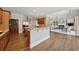 Open kitchen with wood floors, wooden cabinets, granite counters, and adjacent living area at 4790 Hyde Rd, Cumming, GA 30040