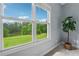 Large windows offering serene views of a lush green lawn and tranquil lake at 4790 Hyde Rd, Cumming, GA 30040