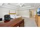 Bright primary bedroom with tray ceiling, desk, and TV at 4459 Sierra Creek Dr, Hoschton, GA 30548