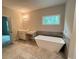 A modern bathroom features a soaking tub, a vanity sink, and a large window at 1025 Liberty Springs Dr, Woodstock, GA 30188