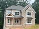 Charming two-story brick home featuring a covered front porch, well-manicured landscaping, and a classic architectural design at 1025 Liberty Springs Dr, Woodstock, GA 30188