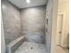 Modern tiled shower with a built-in bench and sleek fixtures at 1025 Liberty Springs Dr, Woodstock, GA 30188