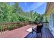Back deck featuring wood flooring, railing, and a picturesque view of lush greenery at 1263 Whisperwood Ln, Lawrenceville, GA 30043