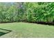 Expansive backyard with lush green lawn, surrounded by trees and a wooden fence, perfect for outdoor activities at 1263 Whisperwood Ln, Lawrenceville, GA 30043