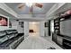 Basement features a large black sectional sofa, TV, sports themed decor, and an open doorway at 1263 Whisperwood Ln, Lawrenceville, GA 30043