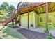 View of walkout basement with garage door and steps leading to the upper deck, surrounded by landscaping at 1263 Whisperwood Ln, Lawrenceville, GA 30043