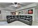 Basement features a large black sectional sofa, sports themed decor, and a ceiling fan at 1263 Whisperwood Ln, Lawrenceville, GA 30043
