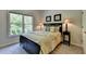 Bedroom features a large window, and a bed with decorative pillows, two framed pictures on the wall, and a lamp at 1263 Whisperwood Ln, Lawrenceville, GA 30043