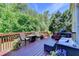 Spacious outdoor deck with comfortable seating and built-in grilling area, perfect for entertaining with lush greenery at 1263 Whisperwood Ln, Lawrenceville, GA 30043