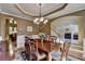 Elegant dining room featuring a chandelier, wainscoting, and a view into the living room at 1263 Whisperwood Ln, Lawrenceville, GA 30043