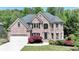 Two-story brick home with mature landscaping, black shutters, and a two-car garage at 1263 Whisperwood Ln, Lawrenceville, GA 30043