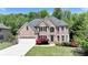 Charming brick facade with well-kept lawn and mature landscaping, offering great curb appeal at 1263 Whisperwood Ln, Lawrenceville, GA 30043