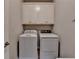 Laundry room features a washing machine, a dryer, and cabinets above at 1263 Whisperwood Ln, Lawrenceville, GA 30043