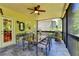 Outdoor screened patio with a dining table set, ceiling fan, and picturesque views of the garden at 1263 Whisperwood Ln, Lawrenceville, GA 30043