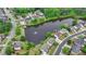 Aerial view of homes surrounding a pond with a fountain in a residential neighborhood at 1263 Whisperwood Ln, Lawrenceville, GA 30043