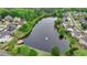 Aerial view of a pond with a fountain surrounded by homes and lush greenery in a neighborhood at 1263 Whisperwood Ln, Lawrenceville, GA 30043