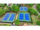 Aerial view of a community featuring four tennis courts, surrounded by trees, and lush greenery at 1263 Whisperwood Ln, Lawrenceville, GA 30043