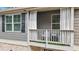 Charming covered balcony with seating, a table, and artificial turf for relaxed outdoor living at 137 White Mountain Pass, Mcdonough, GA 30252