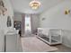 Bedroom with a white crib, soft pink accents, and decorative details for a cozy atmosphere at 137 White Mountain Pass, Mcdonough, GA 30252