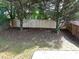 A fenced backyard offers privacy with trees adding natural beauty to the property at 415 Village Way, Woodstock, GA 30188
