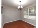 Cozy dining area featuring a chandelier, hardwood floors, and a large window at 415 Village Way, Woodstock, GA 30188