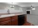Bright kitchen with wood cabinets, a dishwasher, and an adjacent living area at 415 Village Way, Woodstock, GA 30188