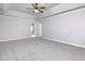 A spacious main bedroom featuring a ceiling fan, tray ceiling, and neutral carpet flooring at 415 Village Way, Woodstock, GA 30188